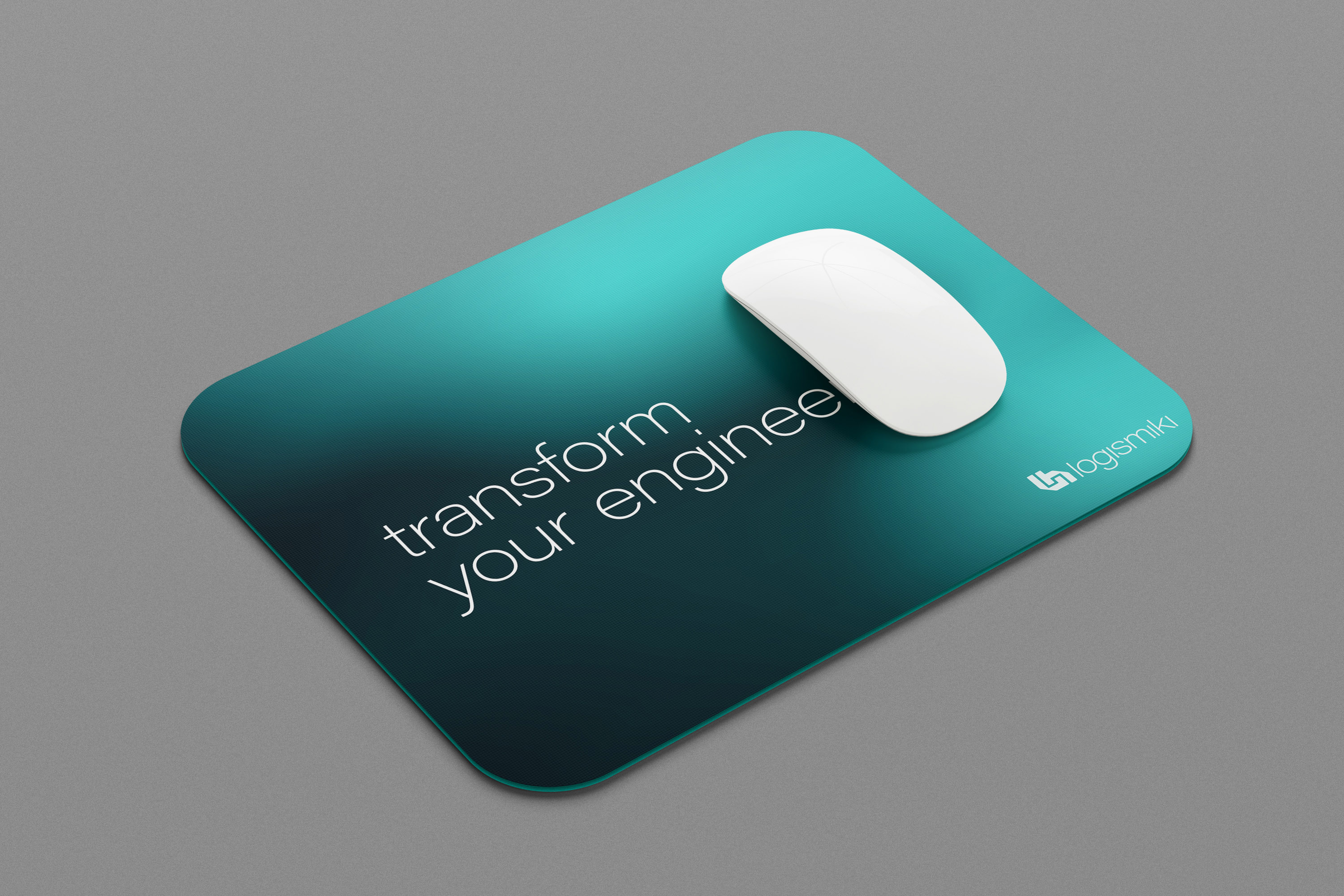 A white computer mouse rests on a dark teal mousepad. The mousepad displays the text "transform your enginee" and the Logismiki logo.