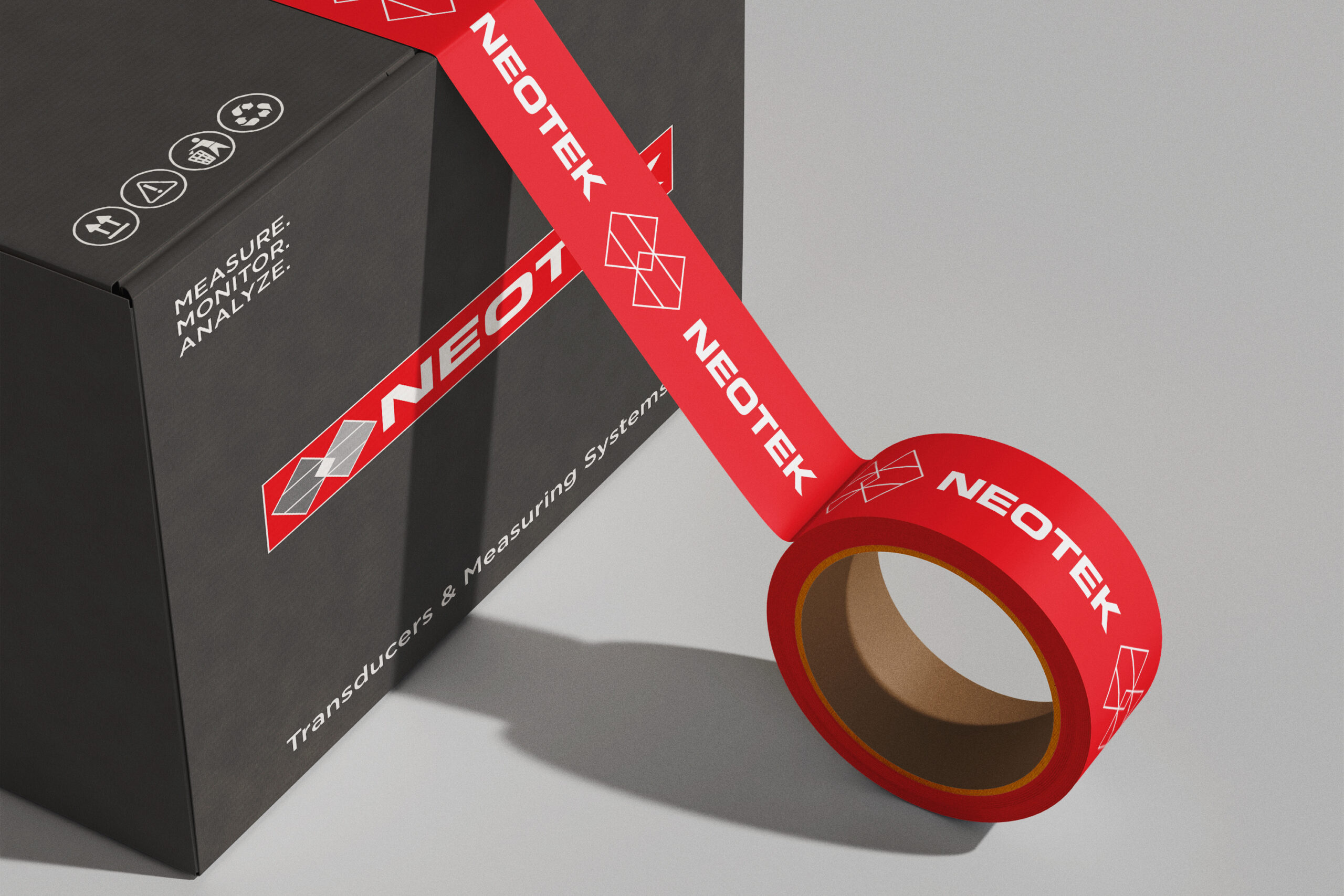 A cardboard box with a red tape roll resting on its surface, indicating preparation for shipping.