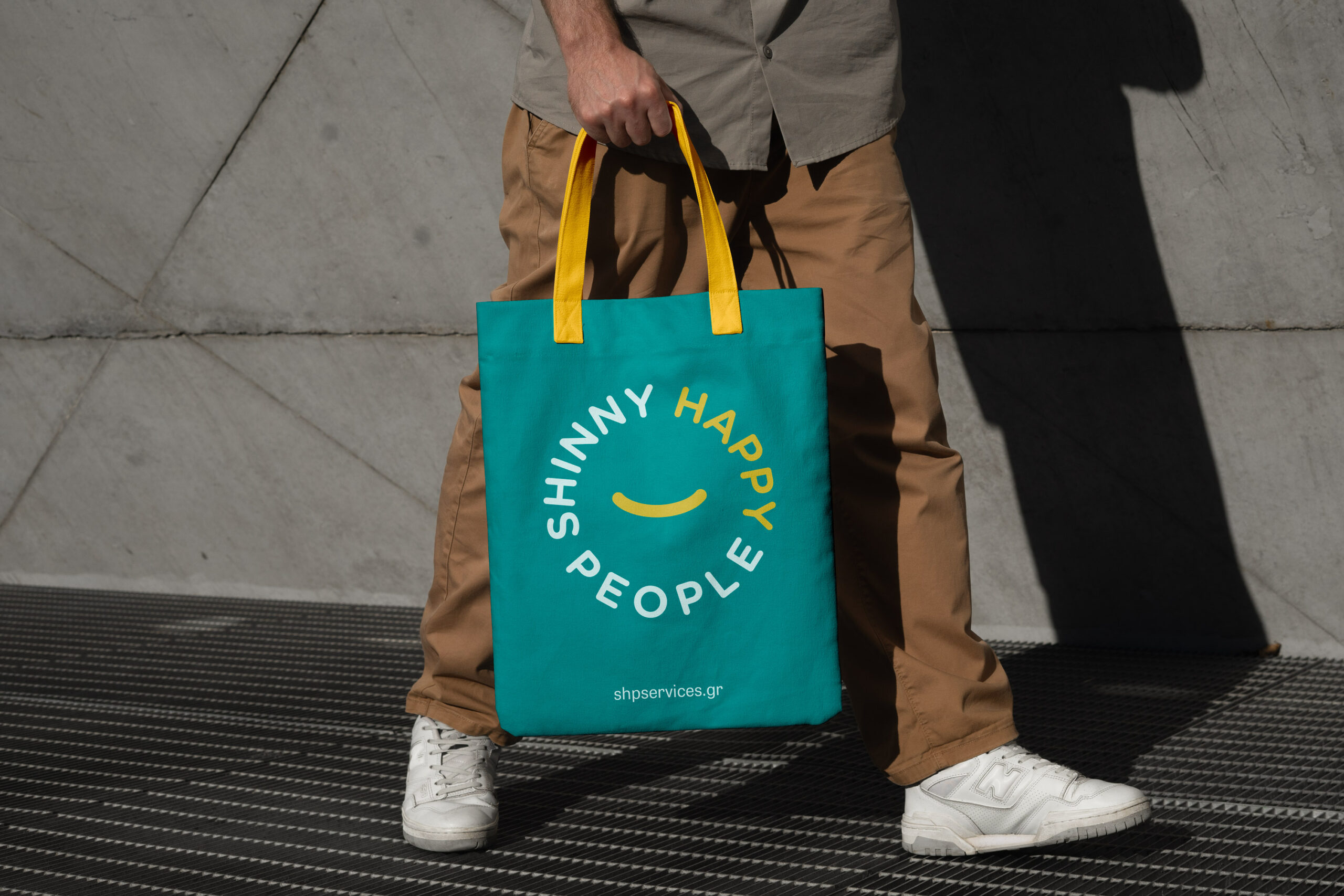 man carries a blue and yellow tote bag, demonstrating its stylish design and practical use for shopping.