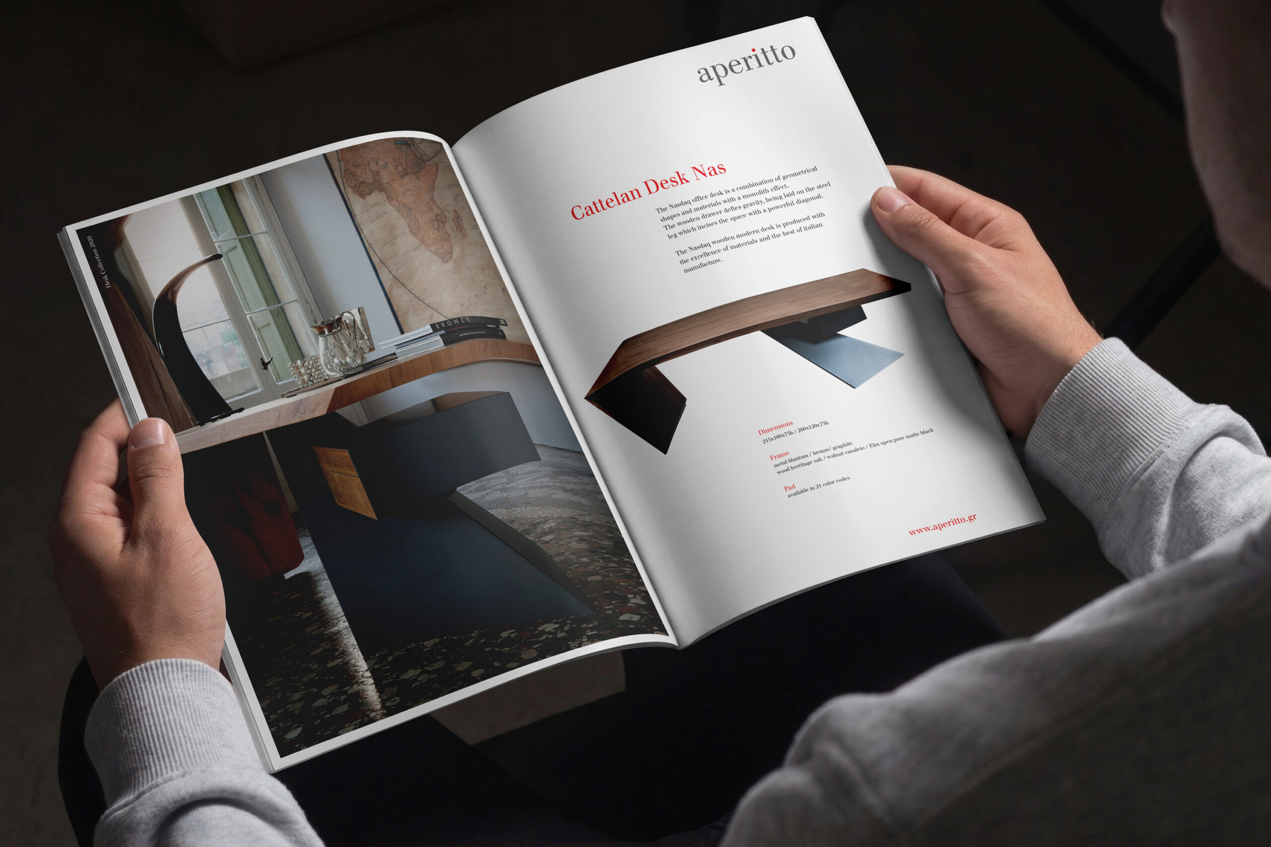 Individual engaged in reading a magazine on editorial design, seated at a desk with a table visible behind them.
