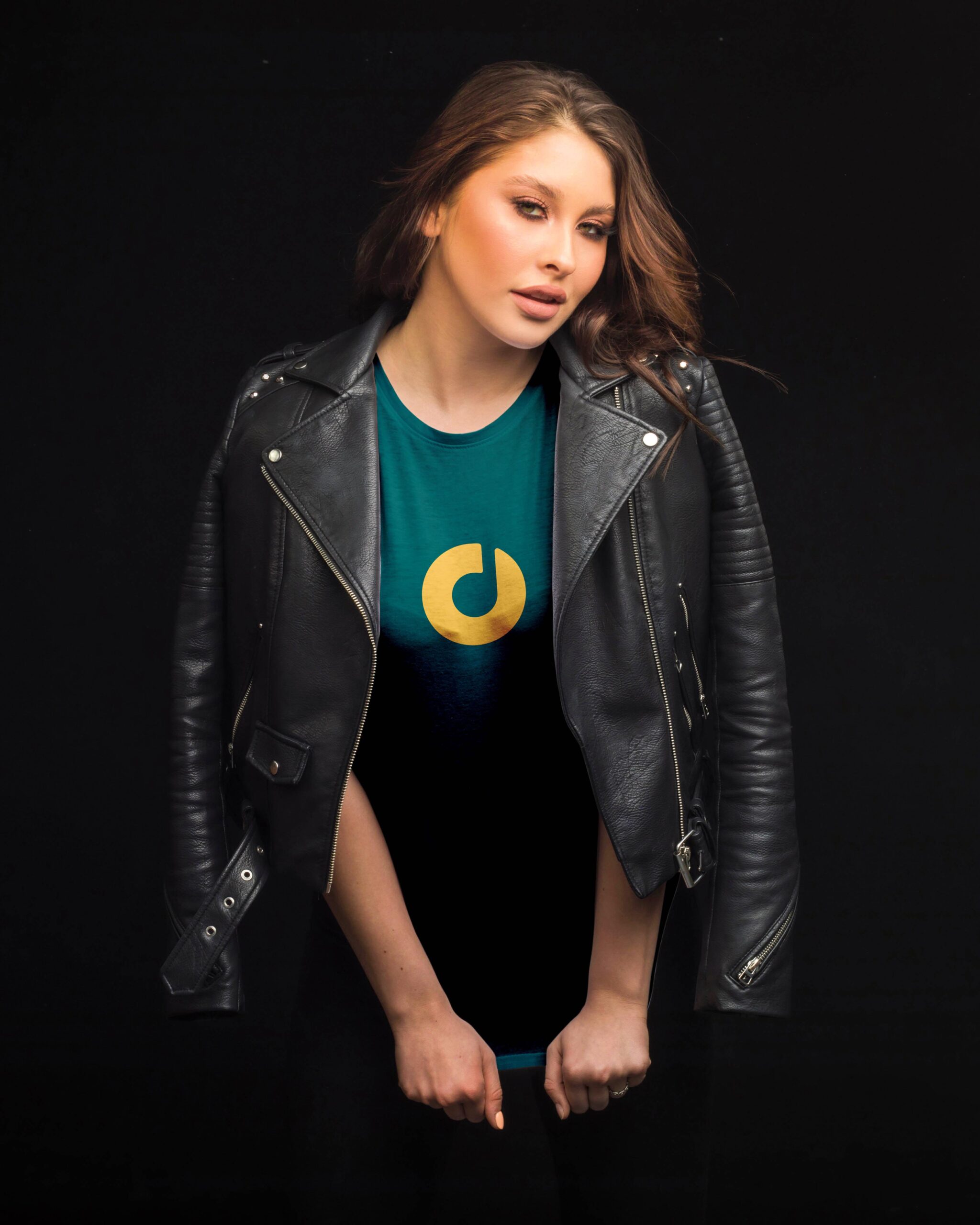 A woman models a green t-shirt with the Floyd Live Music Venue emblem, paired with a black leather jacket.