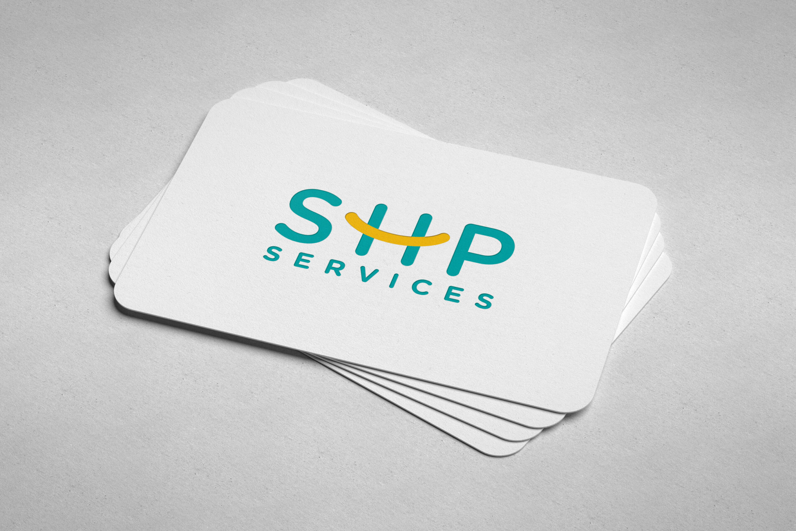 Elegant SHP Services logo displayed on white velvet laminated business cards, featuring round corners for a refined look.